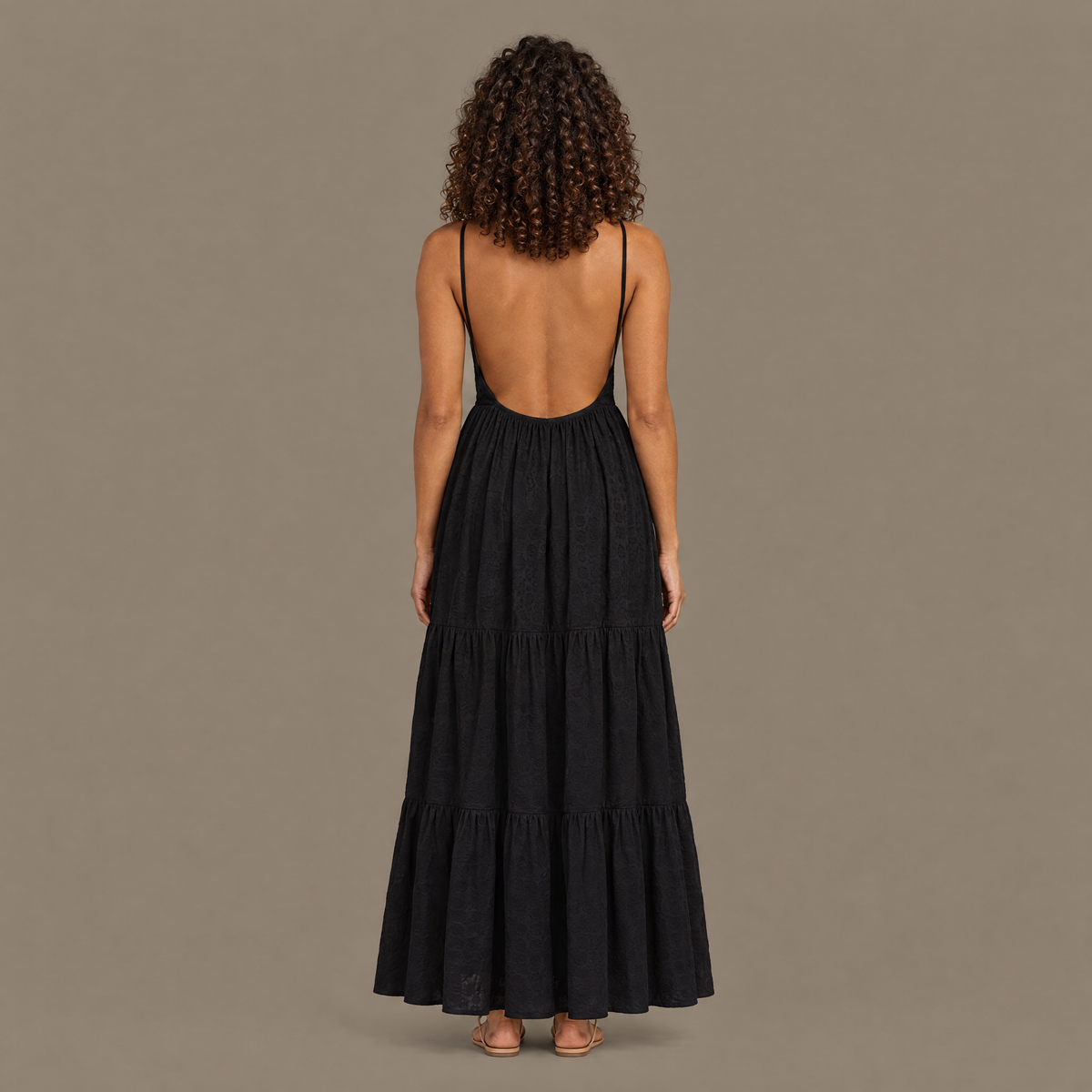 Back view of the black tiered maxi dress showing the open back and fine shoulder straps