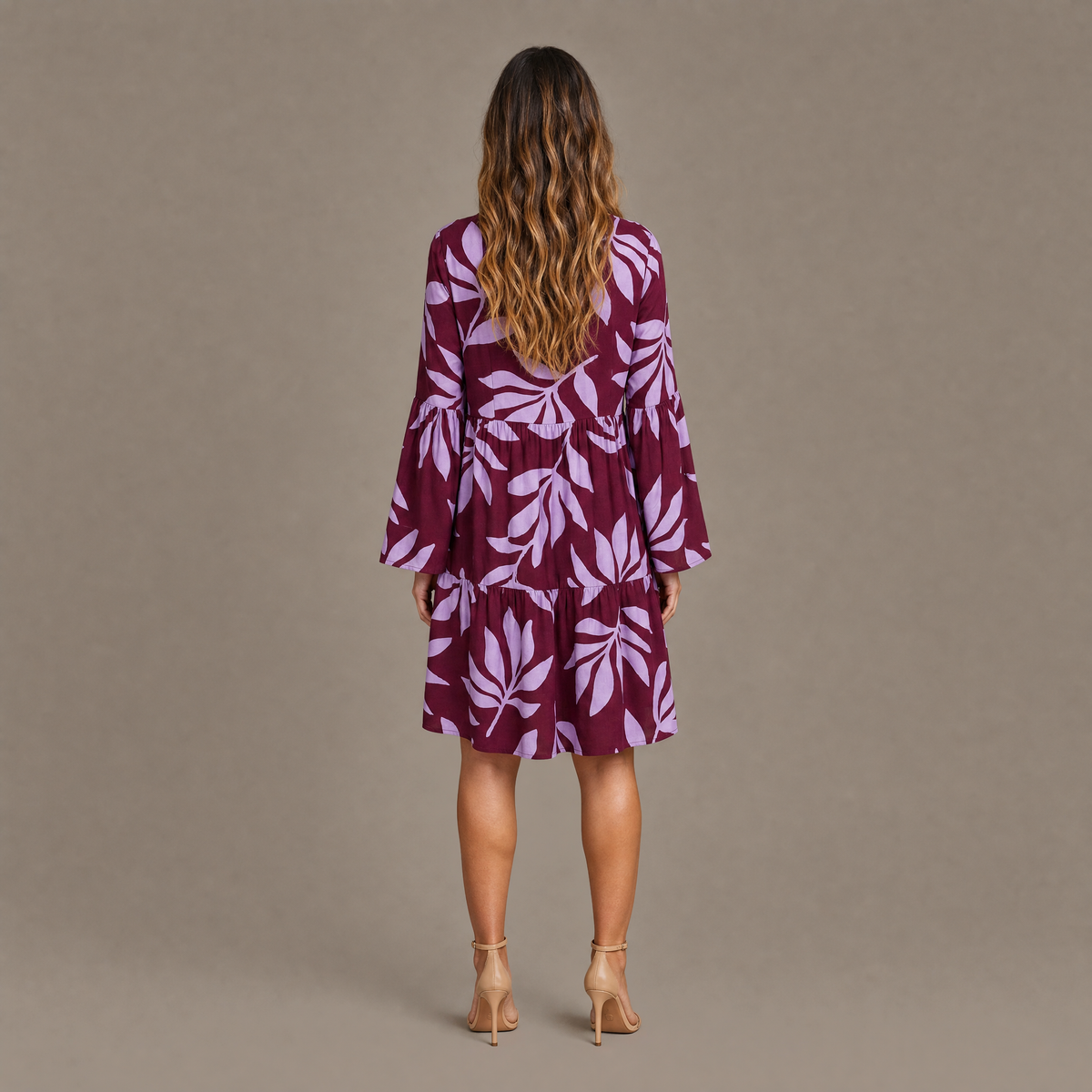 Back view of the burgundy leaf print long sleeve tiered mini dress