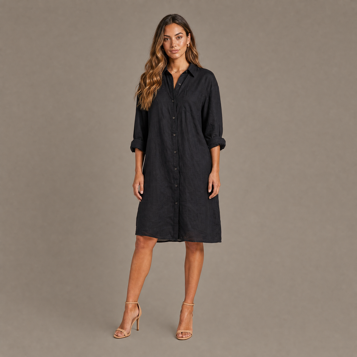 Woman wearing the black oversized linen blend button down shirt dress, front view