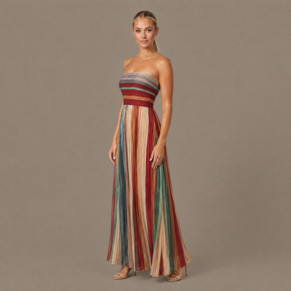 Pleated striped strapless maxi dress seen from a three-quarter angle, showing how the pleats fall